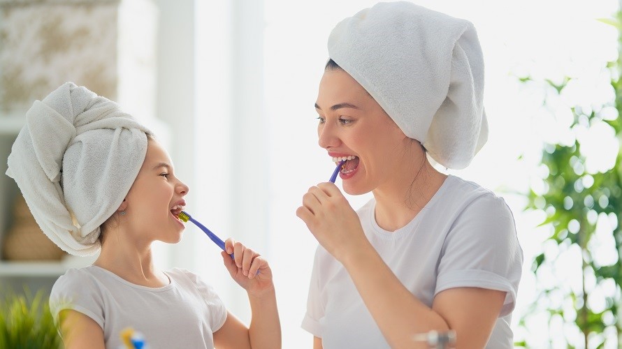 Mutter und Tochter putzen gemeinsam Zähne Mutter und Tochter putzen gemeinsam Zähne